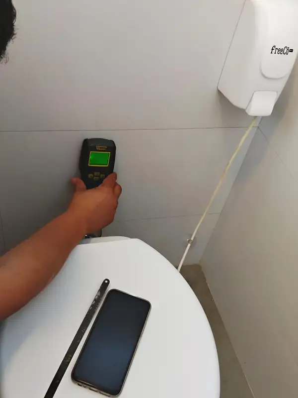 Leitura de umidade: O aparelho mostra até onde a água avançou dentro da alvenaria atrás do vaso.